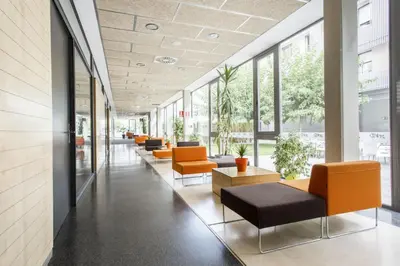a row of chairs in a lobby with windows at Residencia Universitaria Resa Damia Bonet in Valencia