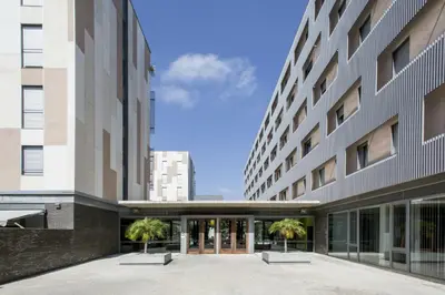an external view of a building with palm trees in the courtyard at Residencia Universitaria Resa Damia Bonet in Valencia