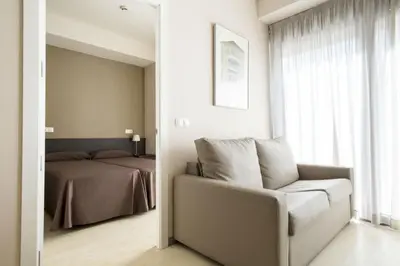 a bedroom with a bed and a chair and a mirror at Residencia Universitaria Resa Damia Bonet in Valencia