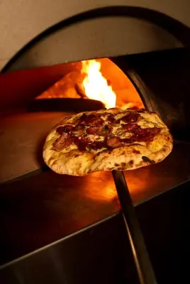 two pizzas are being cooked in an oven at Hotel Benetusser in Benetúser