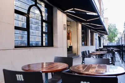 a row of tables and chairs outside of a restaurant at Hotel Benetusser in Benetúser