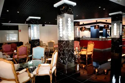 a room with chairs and a table and a bar at Hotel Benetusser in Benetúser
