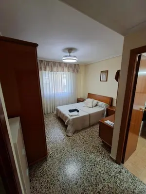 a bedroom with a bed and a living room at APARTAMENTO BEATRIZ 2 in Burriana