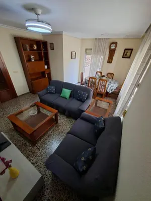 a living room with a blue couch and a table at APARTAMENTO BEATRIZ 2 in Burriana