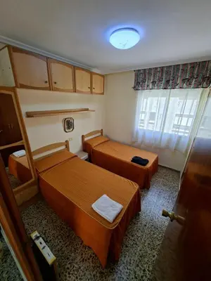 a small room with two beds and a window at APARTAMENTO BEATRIZ 2 in Burriana