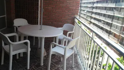 a white table and chairs on a balcony with a window at Cullera Beach by Zagal Apartments in Cullera