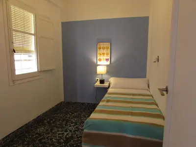 a small room with a bed and a window at Cullera Beach by Zagal Apartments in Cullera