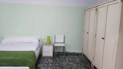 a bedroom with a bed and a cabinet and a chair at Cullera Beach by Zagal Apartments in Cullera