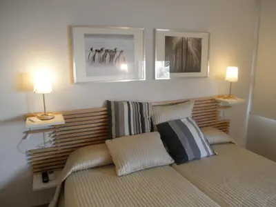 a bedroom with a bed with two lamps and two pictures at Dormavalencia Hostel in Valencia