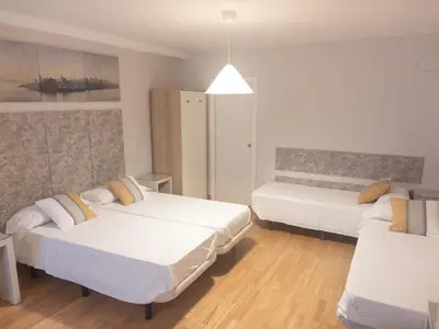 two beds in a room with white walls and wooden floors at Dormavalencia Hostel in Valencia