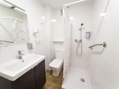 a white bathroom with a toilet and a sink at Dormavalencia Hostel in Valencia