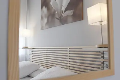 a mirror reflection of a bed with two pillows at Dormavalencia Hostel in Valencia