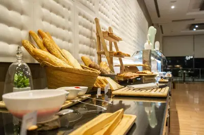 a buffet line with baskets of bread on a counter at AZZ Valencia Congress Hotel & Spa in Paterna