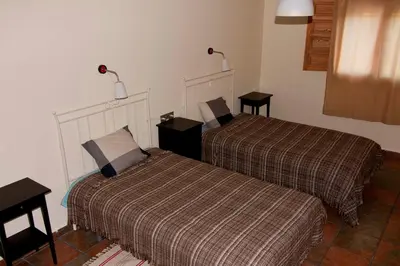 a hotel room with two beds and two tables at El mirador del norte in Cortez de Pallas