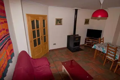 a living room with a red couch and a stove at El mirador del norte in Cortez de Pallas