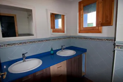 a bathroom with two sinks and two mirrors at El mirador del norte in Cortez de Pallas