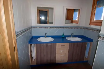 a bathroom with two sinks and a blue counter at El mirador del norte in Cortez de Pallas