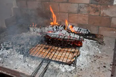 a grill with a bunch of hot dogs on fire at El mirador del norte in Cortez de Pallas