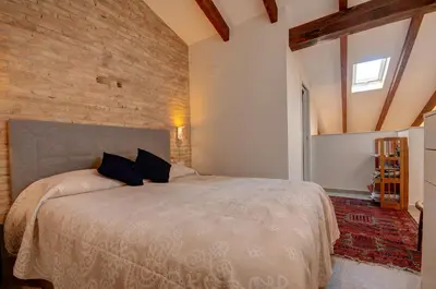 a bedroom with a large bed with a brick wall at Beds & Breaks Verdi 2 in Valencia