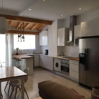 a kitchen with white appliances and a table and a dining room at Domus Valencia Apartamentos Loft zona Pechina in Valencia