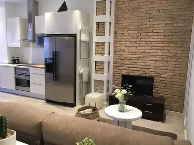 a living room with a couch and a brick wall at Domus Valencia Apartamentos Loft zona Pechina in Valencia