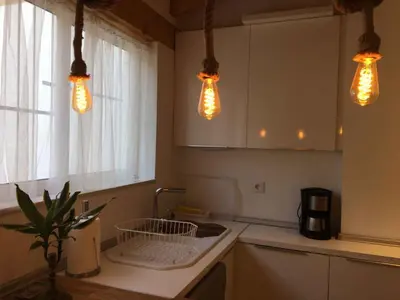 a kitchen with three lights hanging over a sink at Domus Valencia Apartamentos Loft zona Pechina in Valencia