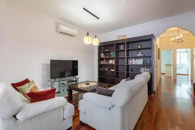 a living room with two white chairs and a tv at Ruzafa Luis Santangel in Valencia