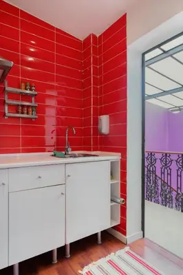 a red kitchen with a sink and a red wall at Purple Nest Hostel in Valencia
