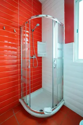 a shower in a bathroom with a red wall at Purple Nest Hostel in Valencia