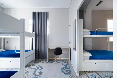 a bedroom with two bunk beds and a chair at Purple Nest Hostel in Valencia