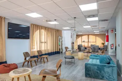 a living room with chairs and a couch and tables at Albergue Juvenil Colegio Mayor Galileo Galilei in Valencia