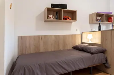 a bedroom with a bed with a wooden headboard at Albergue Juvenil Colegio Mayor Galileo Galilei in Valencia