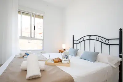 a bedroom with a large white bed with a tray on it at Apartments Cullera Beach in Cullera