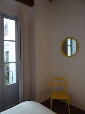 a bedroom with a yellow chair and a mirror at Valencia what else... in Valencia
