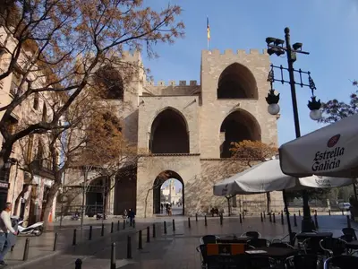 a building with a clock tower and tables and chairs at Valencia what else... in Valencia