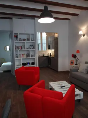 a living room with red chairs and a couch at Valencia what else... in Valencia