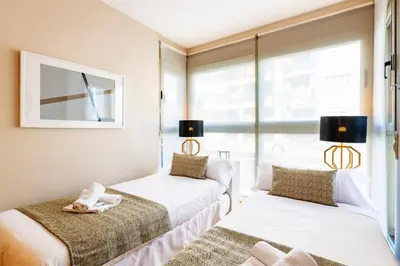 two beds in a room with a window at MD Abastos in Valencia