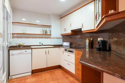 a kitchen with white cabinets and marble counter tops at MD Abastos in Valencia