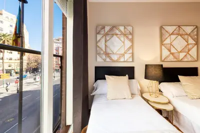 two beds in a room with a window at MD Abastos in Valencia