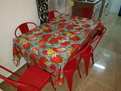 a red table and chairs with a tablecloth with fruit on it at Apartamento Sofia in Valencia