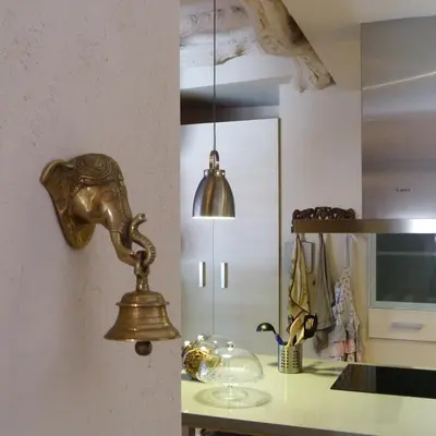 a gold bell hanging on a wall in a kitchen at Dalt Vila in Eslida
