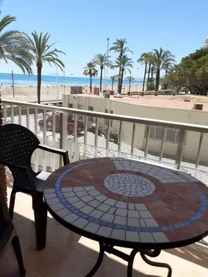 a patio with a table and chairs and the beach at Apartamento a 10 metros del mar in Cullera