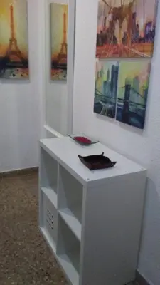 a white desk in a room with paintings on the wall at Apartamento a 10 metros del mar in Cullera
