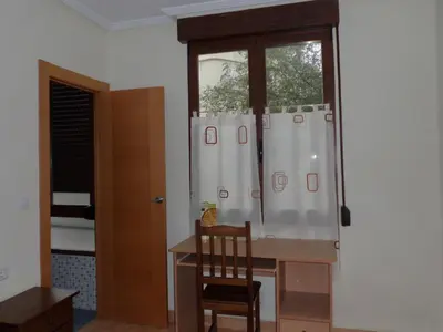 a room with a desk and a window with a chair at Hostal Abastos in Valencia