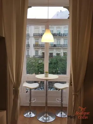 a table and two stools in front of a window at The Art Boutique Colon in Valencia