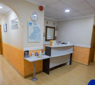 a waiting room with a desk and a clock on the wall at Hotel Beatriz in Burriana