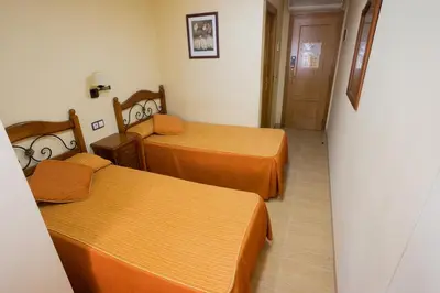 a small room with two beds and a hallway at Hotel Beatriz in Burriana