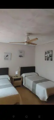 a bedroom with two beds and a ceiling fan at Piso Colon in Paiporta