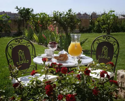 a table with a pitcher of orange juice and a plate of food at La Mozaira in Alboraya