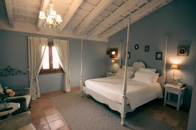 a bedroom with a four poster bed and a chandelier at La Mozaira in Alboraya